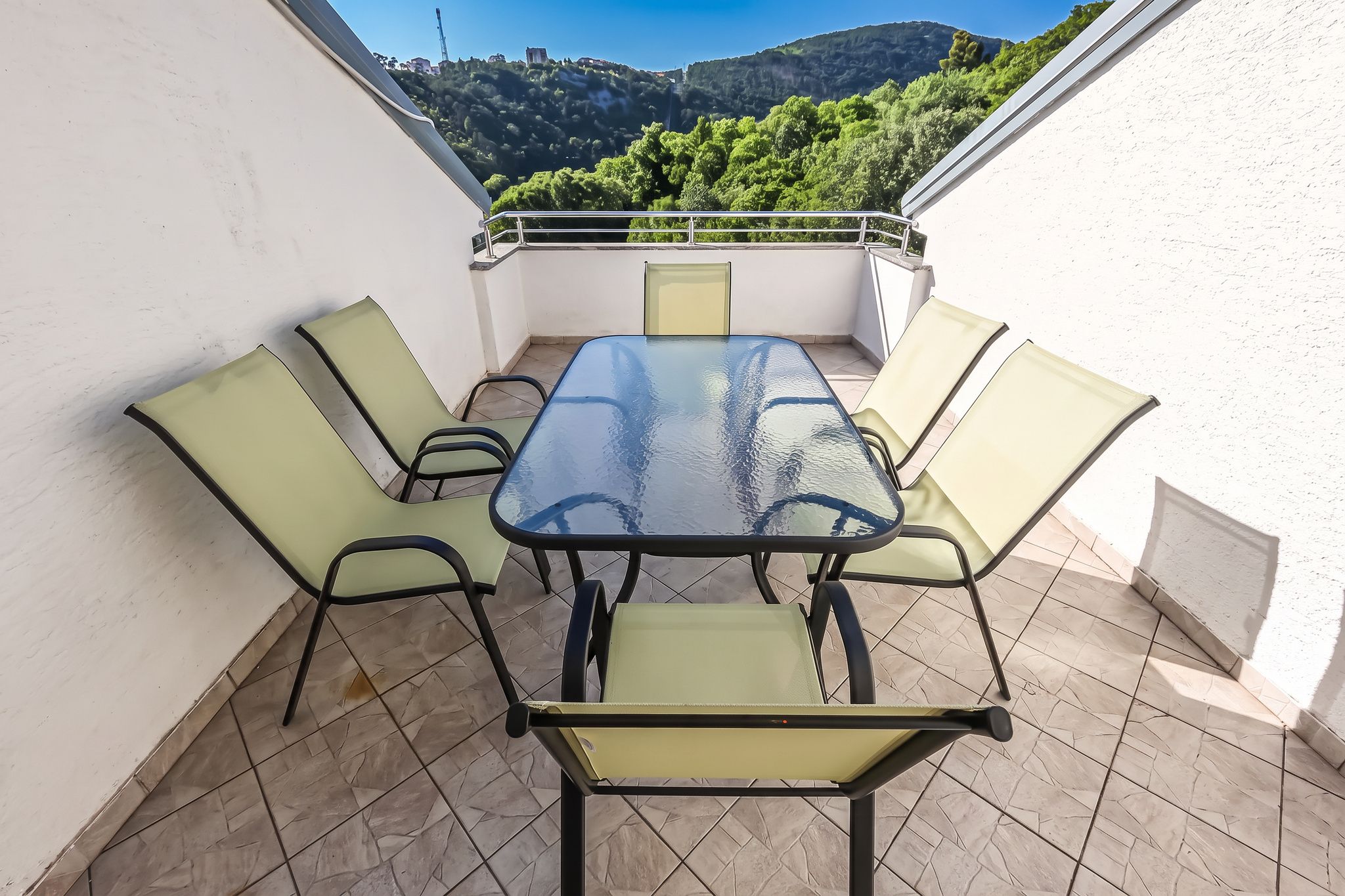 The four-bedroom's own roof balcony, table and chairs under the hill